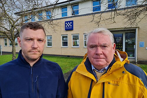 Henry Batchelor and Peter McDonald in front of a police station